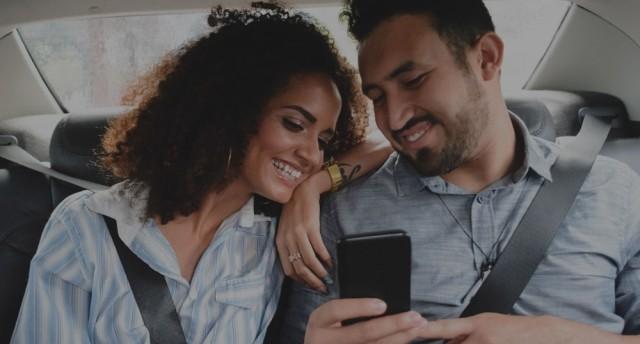 Couple in car with phone